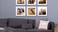 Fotowand mit Rasterhängung Das Bild zeigt eine Fotowand in Rasterhängung mit Familienbildern über einem Sofa.