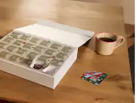 Créez un calendrier de l’Avent puzzle avec votre propre photo. Un calendrier de l’Avent puzzle est posé sur une table, avec les premières cases ouvertes.
