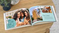 Álbum de fotos de viajes con texto Un libro de fotos de vacaciones abierto con imágenes de Barcelona sobre una mesa. Las páginas del álbum se han diseñado con texto y diversos elementos de diseño.