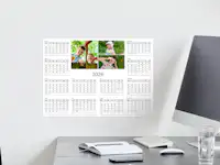 Jahresplaner mit Familienfotos gestalten Ein Jahresplaner mit Familienfotos hängt an einer Wand eines Homeoffice-Zimmers.