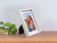 Foto con marco blanco de madera Foto con marco blanco de madera con la foto de dos amigas sobre una cómoda