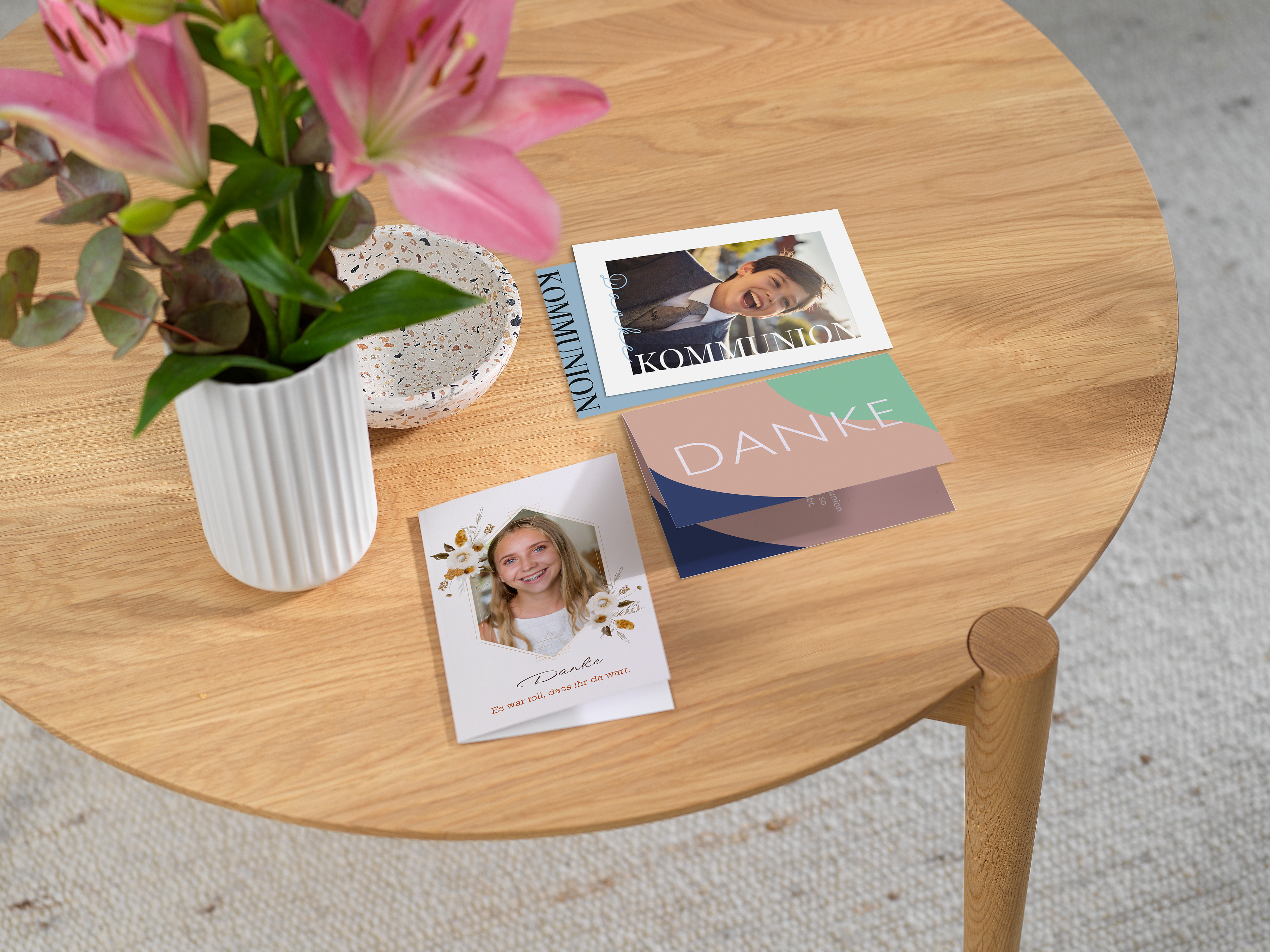 Drei Danksagunskarten zur Kommunion sind auf einem Tisch platziert.
