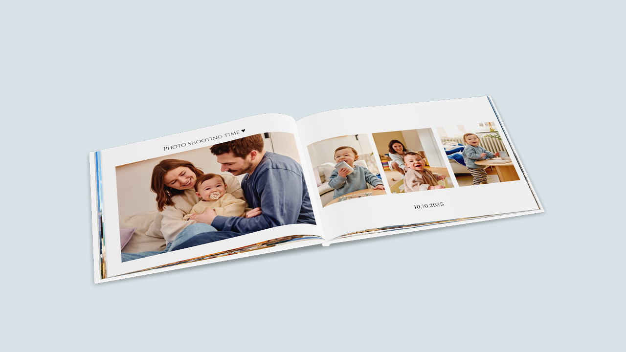 Ein aufgeschlagenes Fotobuch zeigt ein modern-schlicht gestaltetes Babyalbum mit kleinen Bildbeschriftrungen.