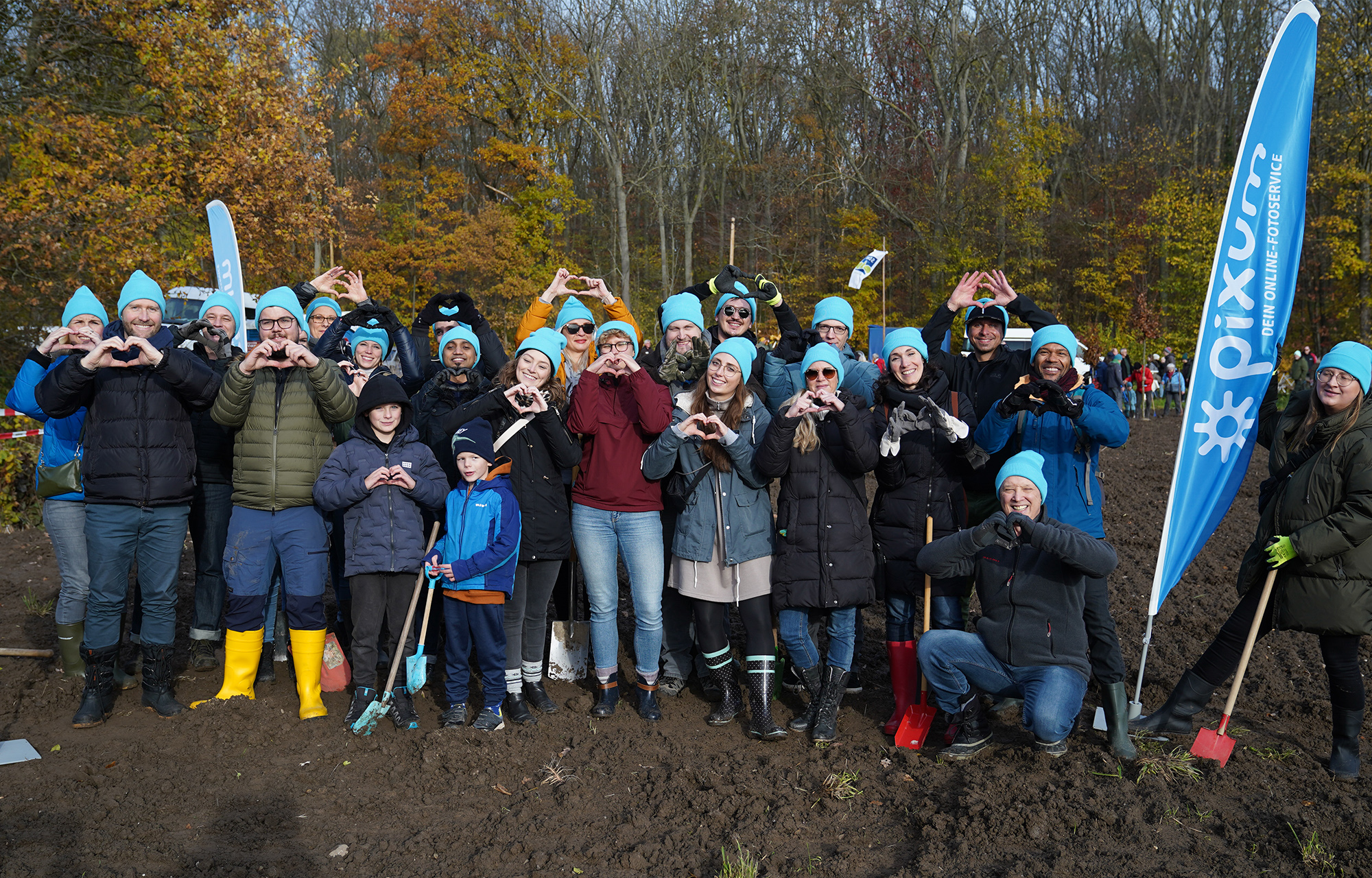 Foto de grupo de trabajadores de Pixum plantando árboles en un bosque