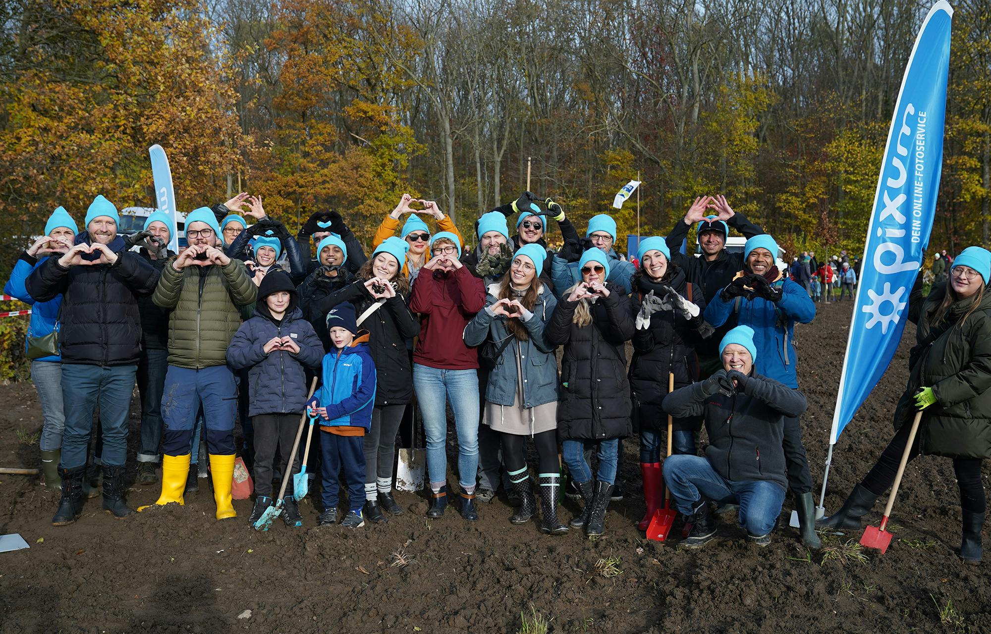 Gruppenfoto von Pixum Mitarbeitenden während der Baumpflanzaktion