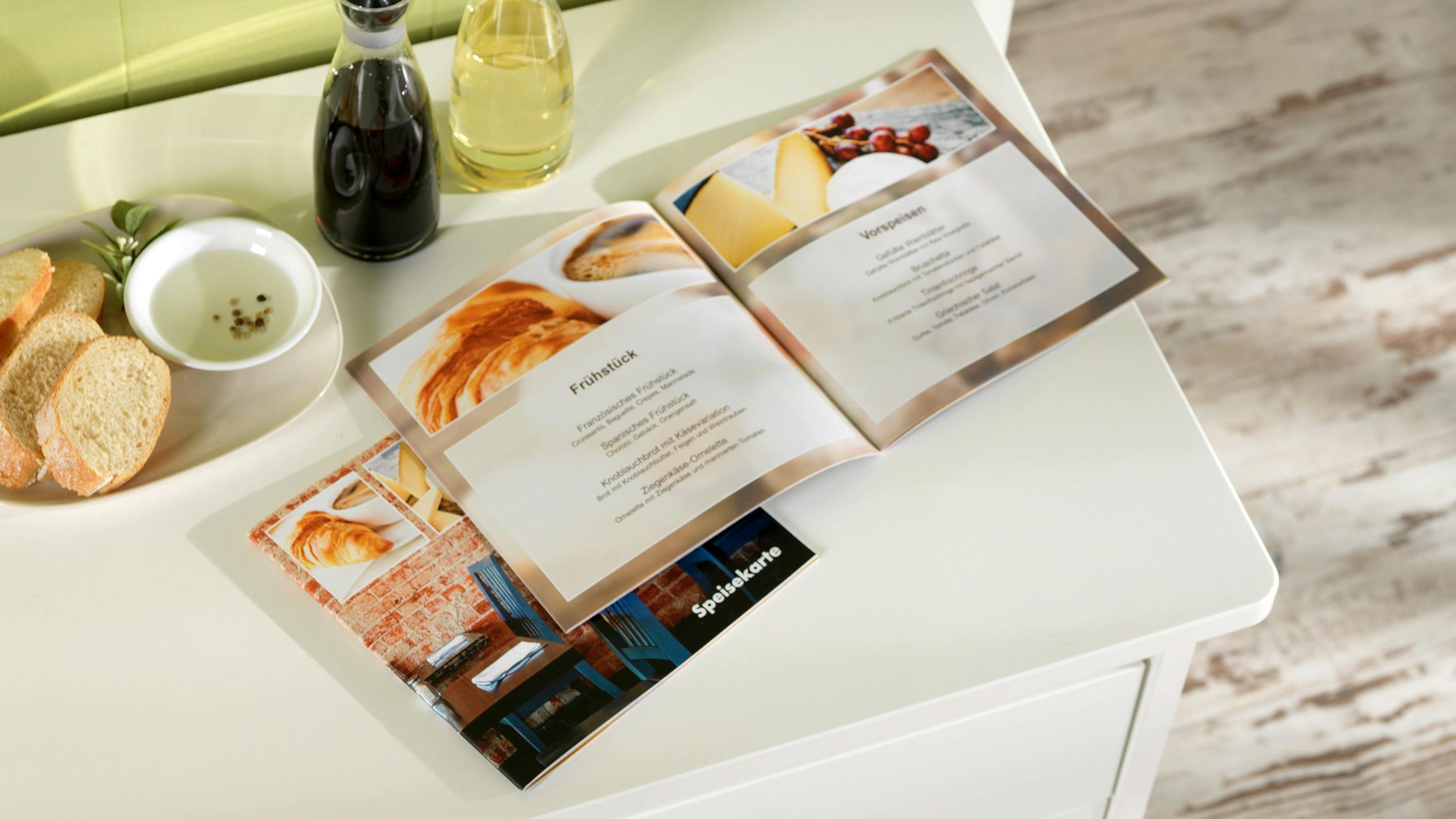Fotobuch mit Softcover, das als Speisekarte gestaltet ist und auf einer Kommode liegt