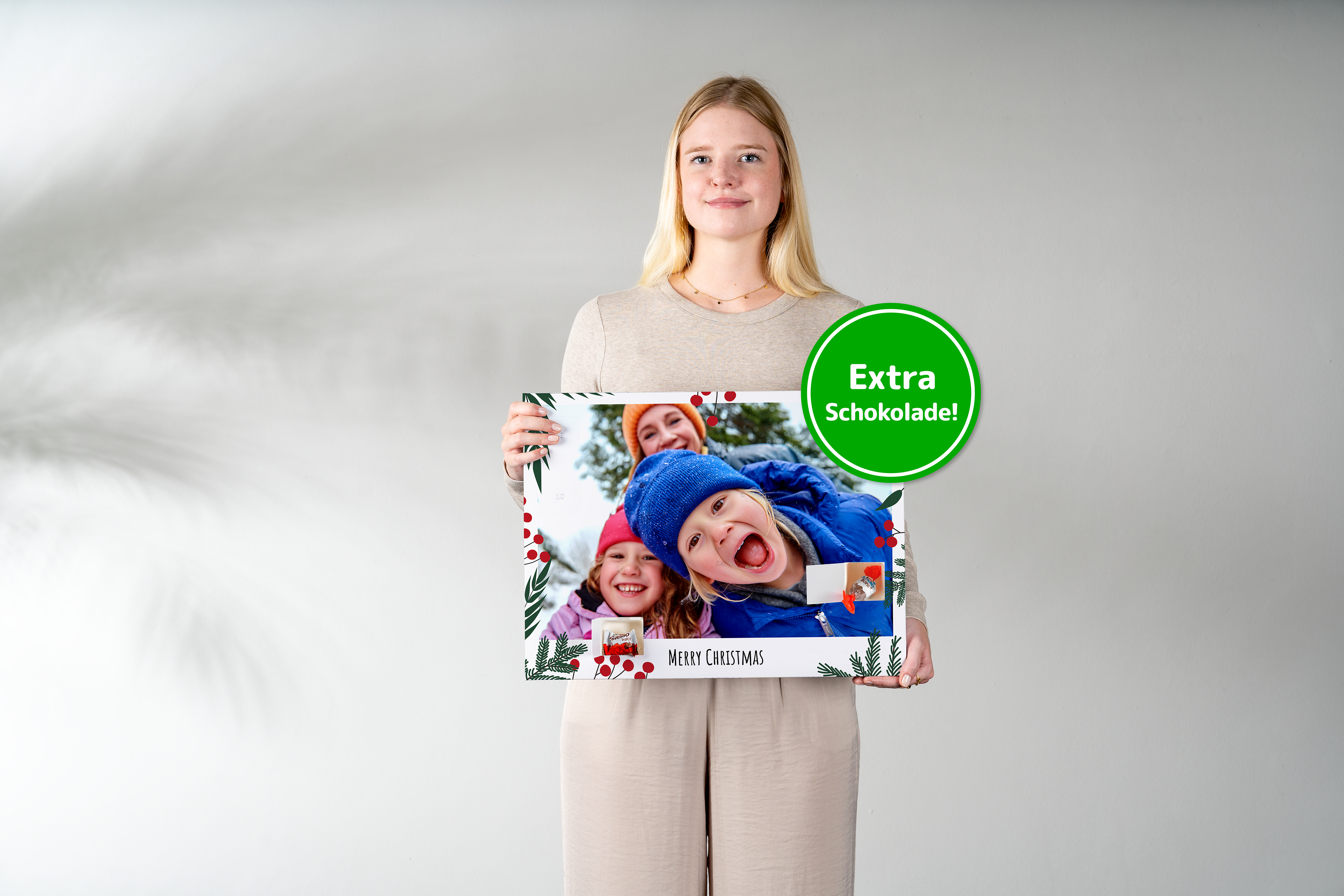 Foto-Adventskalender mit Schokolade in der Hand gehalten