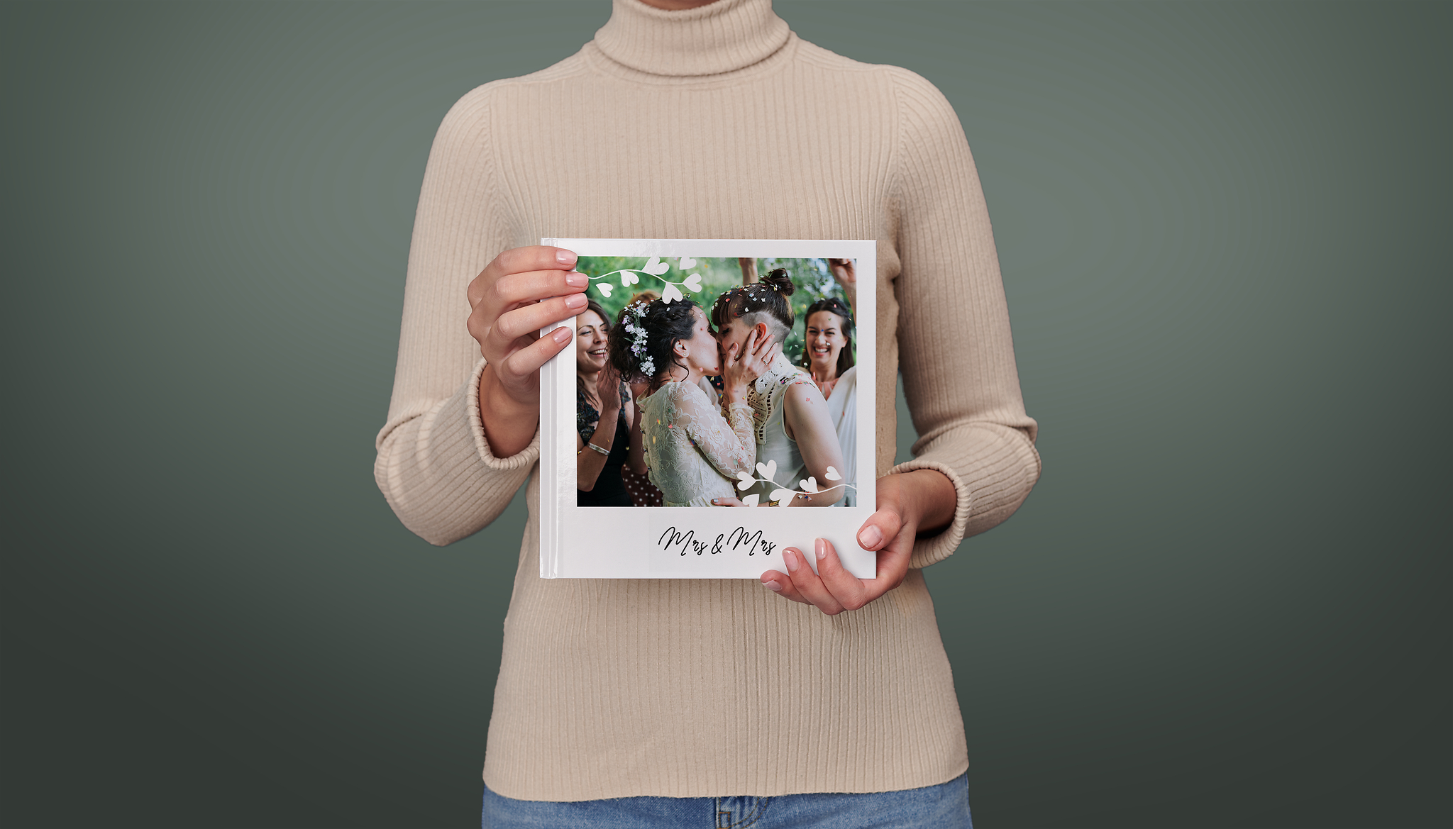 Eine Frau hält ein großes, quadratisches Hochzeitsfotobuch. Auf dem Cover ist ein Hochzeitsbild von zwei Frauen zu sehen.