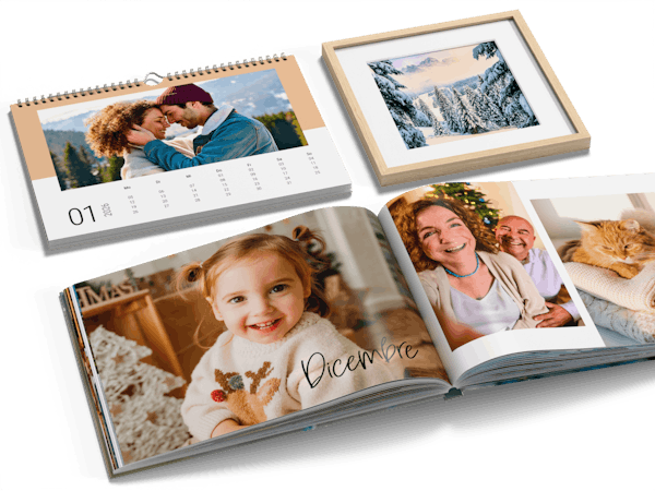 Pixum Fotoboek, wandkalender en wanddecoratie met winterfoto's liggen naast elkaar.