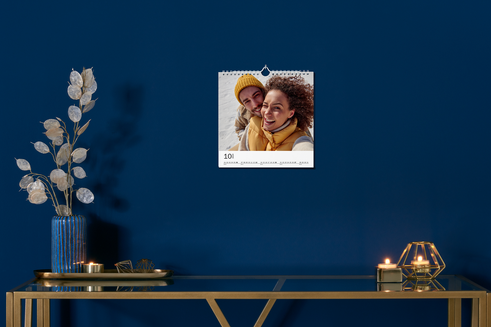 Petit calendrier mural avec une photo de couple sur un mur bleu marine