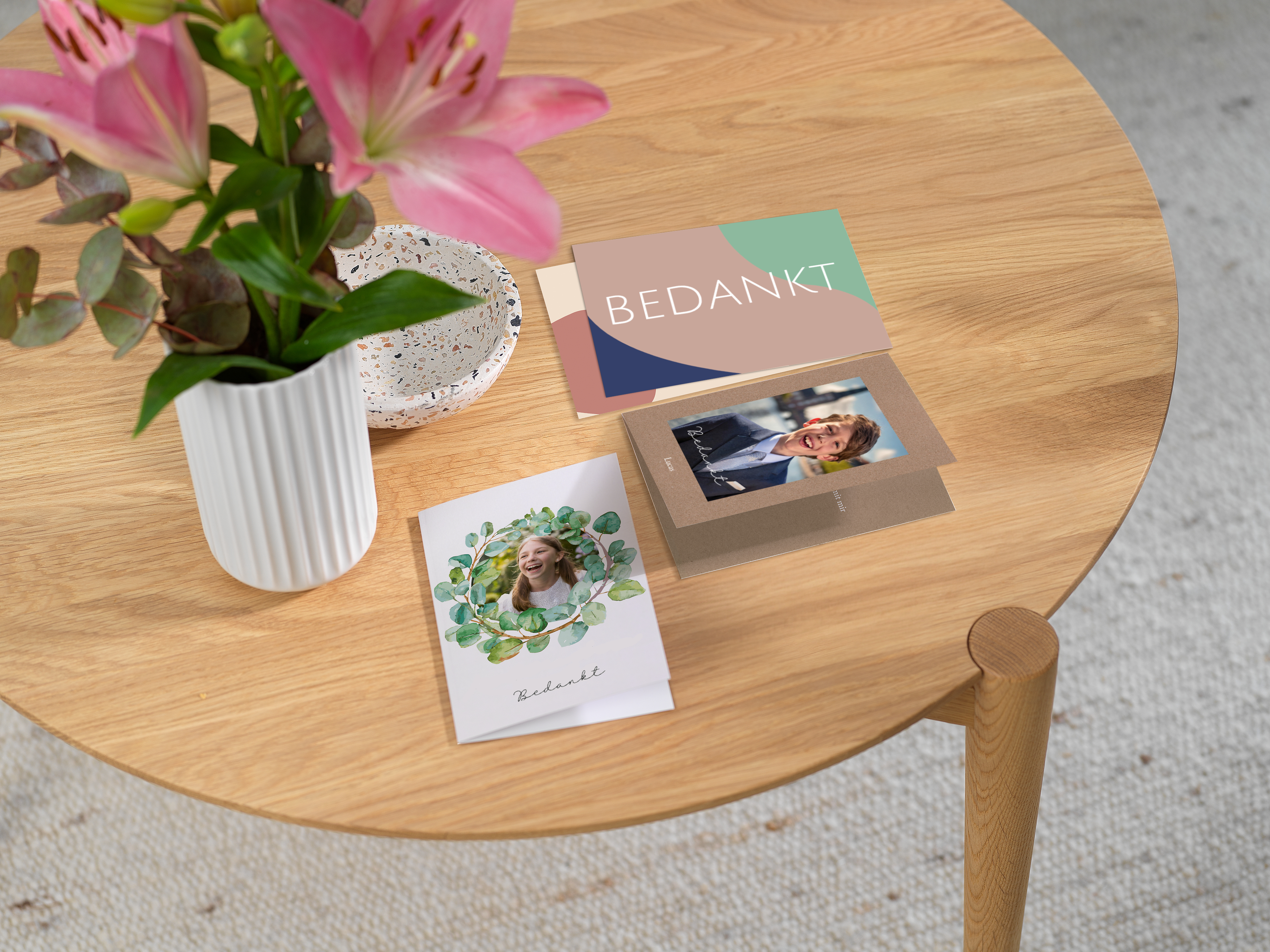 Drie bedankkaartjes voor de communie liggen naast elkaar op een tafel.