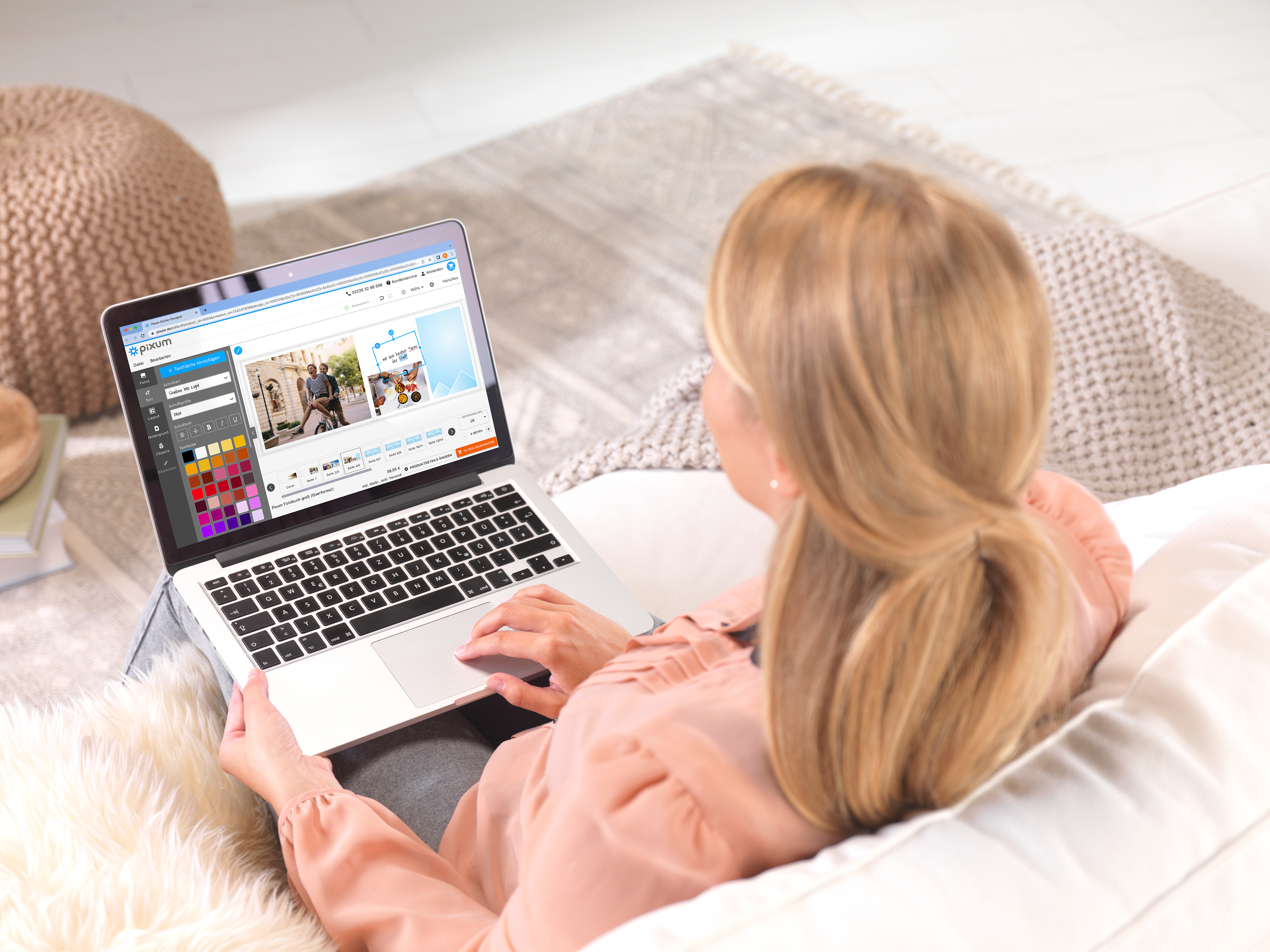 Eine Frau gestaltet auf einem Sofa im Pixum Editor ein Fotobuch