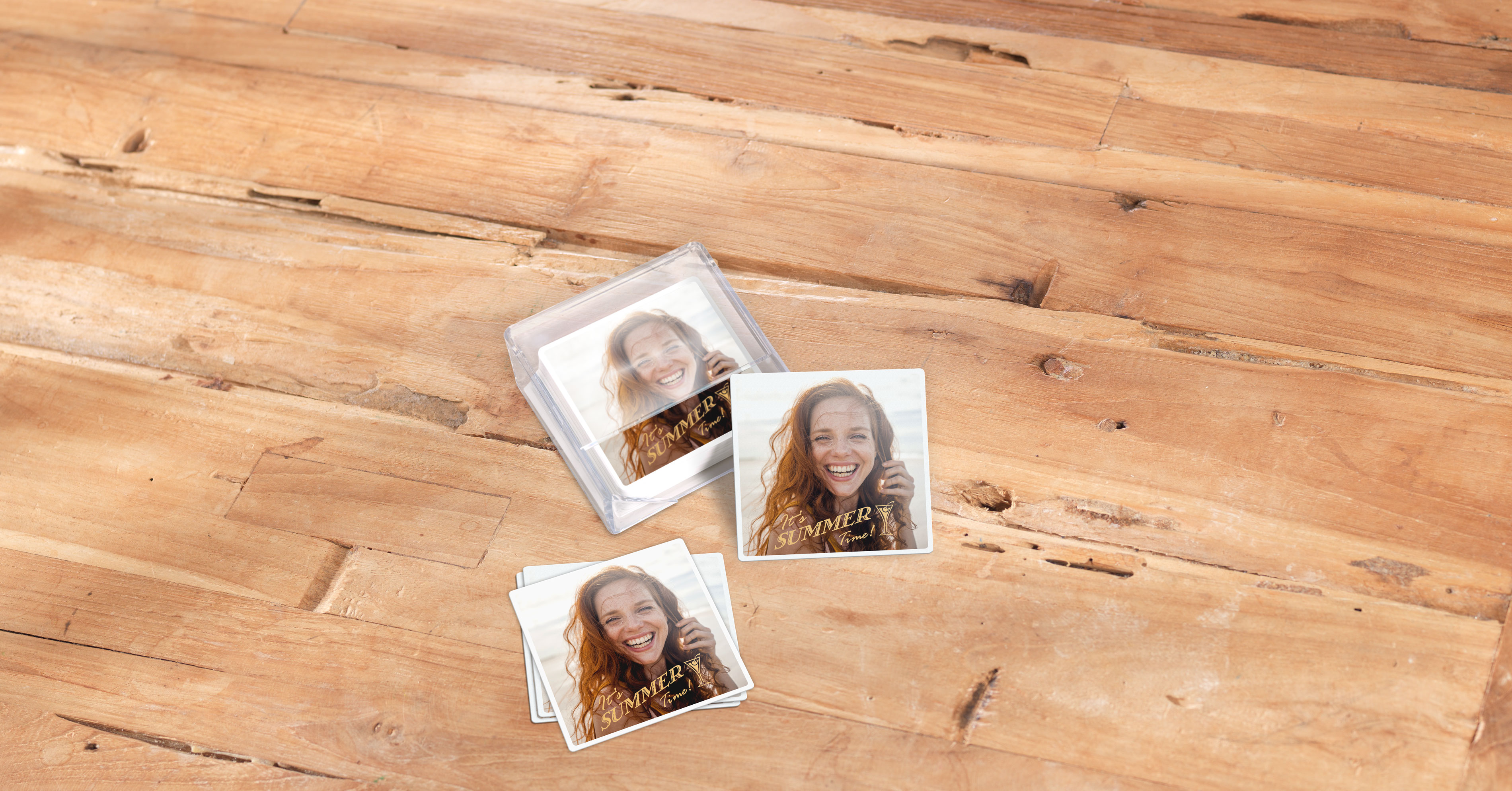 Foto-Untersetzer mit Acrylbox liegen auf einem Tisch. Sie zeigen ein sommerliches Motiv einer Frau.