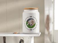 Pot met deksel met een foto van een hond Een pot met een foto van een hond erop staat op een schap.