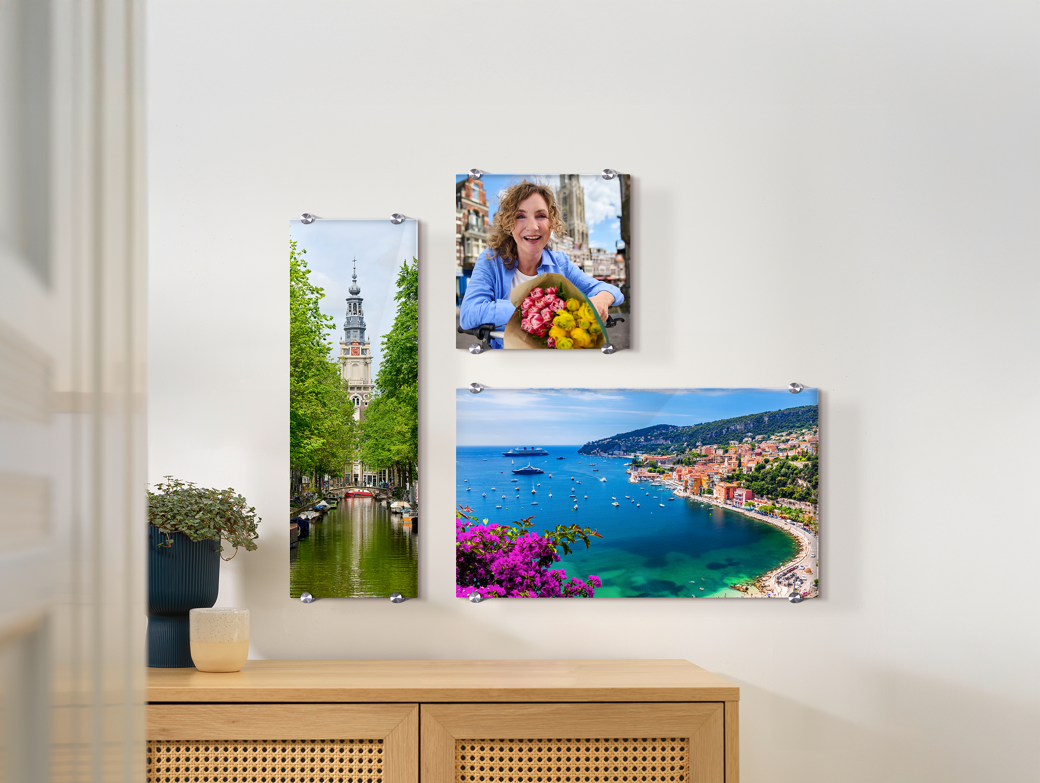 Drie foto's op acrylglas in verschillende formaten hangen aan de muur. Het gaat om vakantiefoto's.