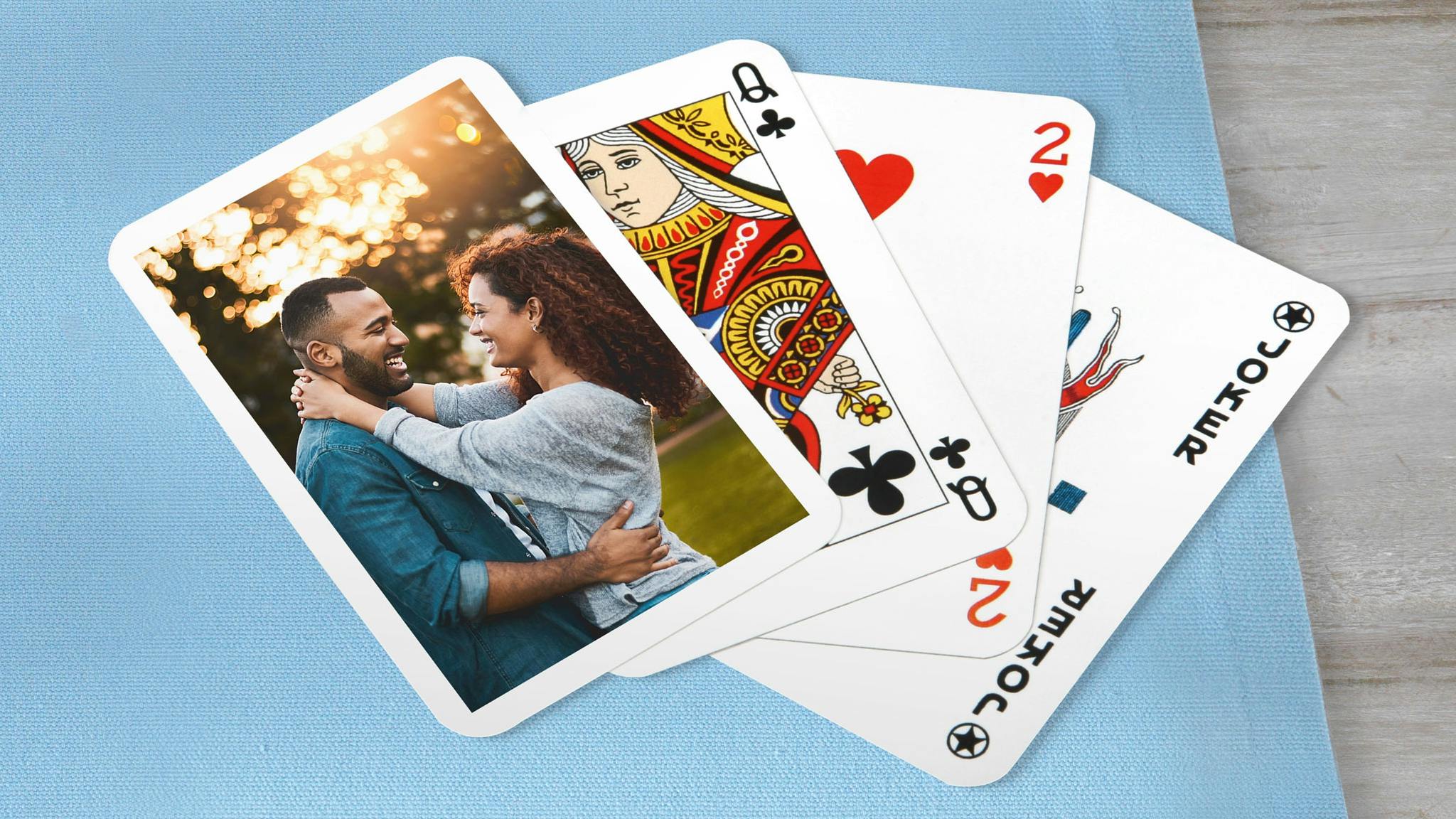 Pokerkarten mit einem Pärchenfoto auf einer blauen Decke