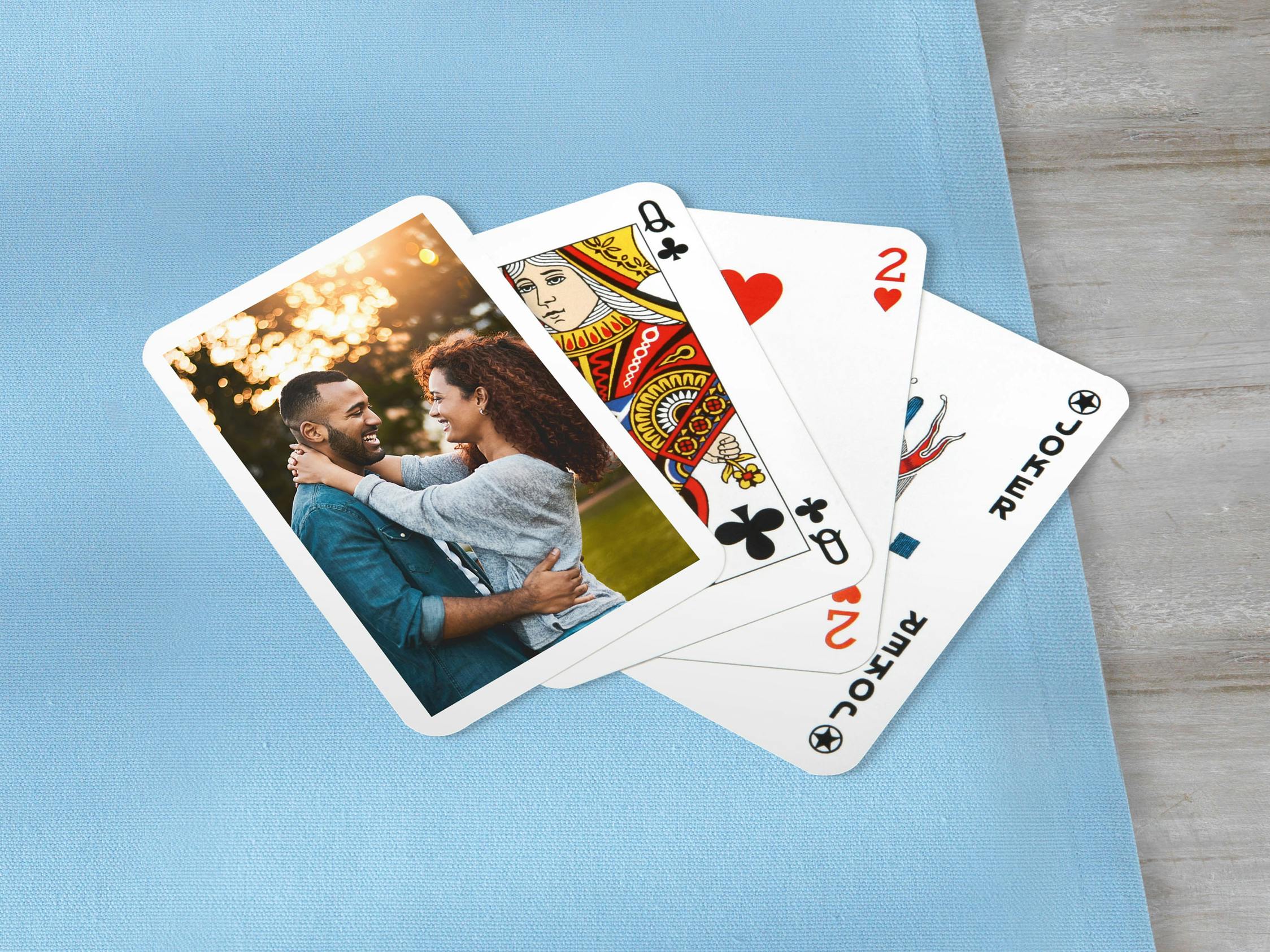 Pokerkarten mit einem Pärchenfoto auf einer blauen Decke