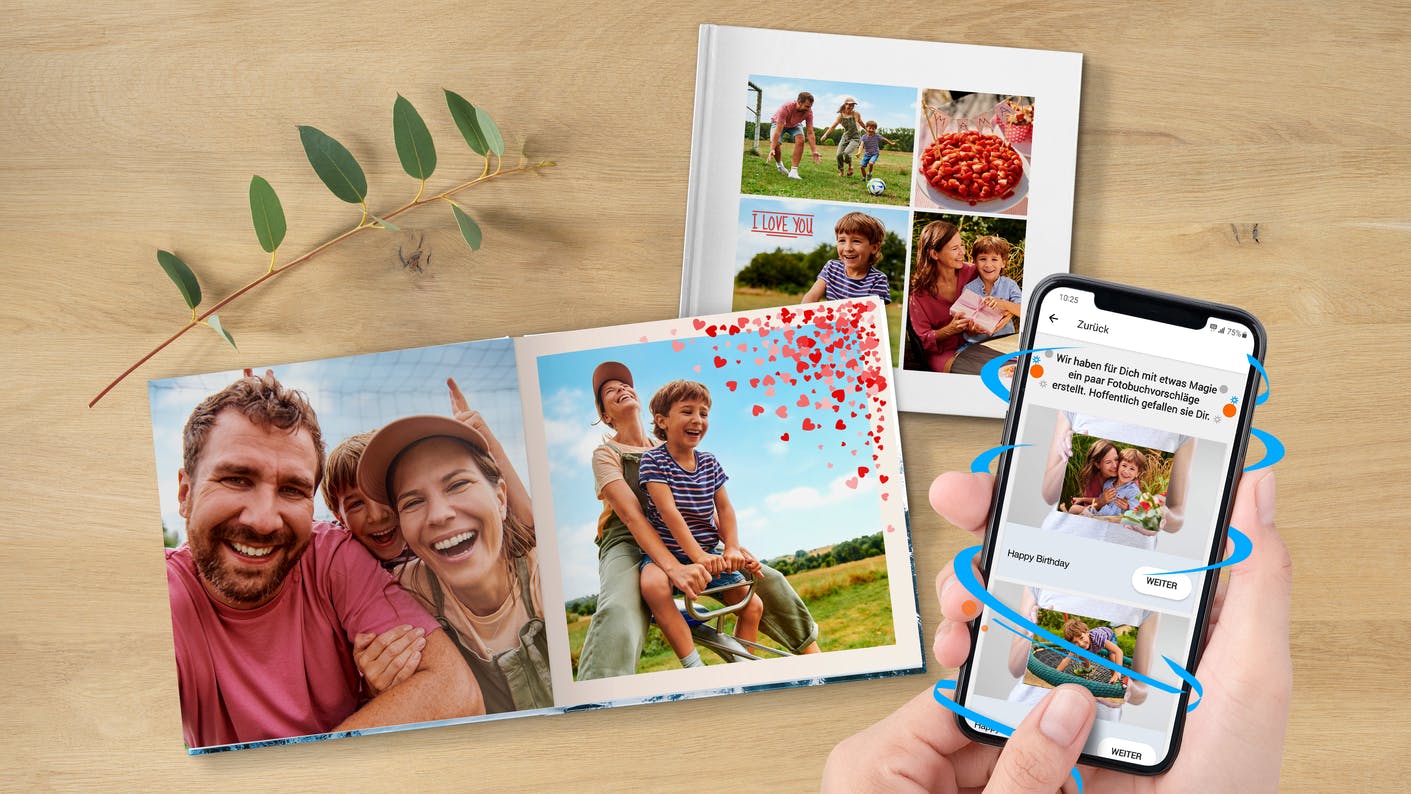 Pixum Fotobuch mit Familienbildern, neben dem ein Handy mit der Pixum App liegt