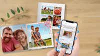 Pixum Fotobuch in der App gestalten Pixum Fotobuch mit Familienbildern, neben dem ein Handy mit der Pixum App liegt