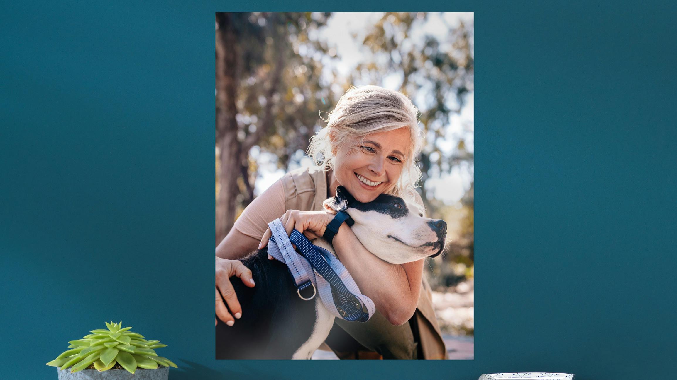 Poster photo accroché au mur avec photo d'une dame et de son chien sur un mur bleu foncé