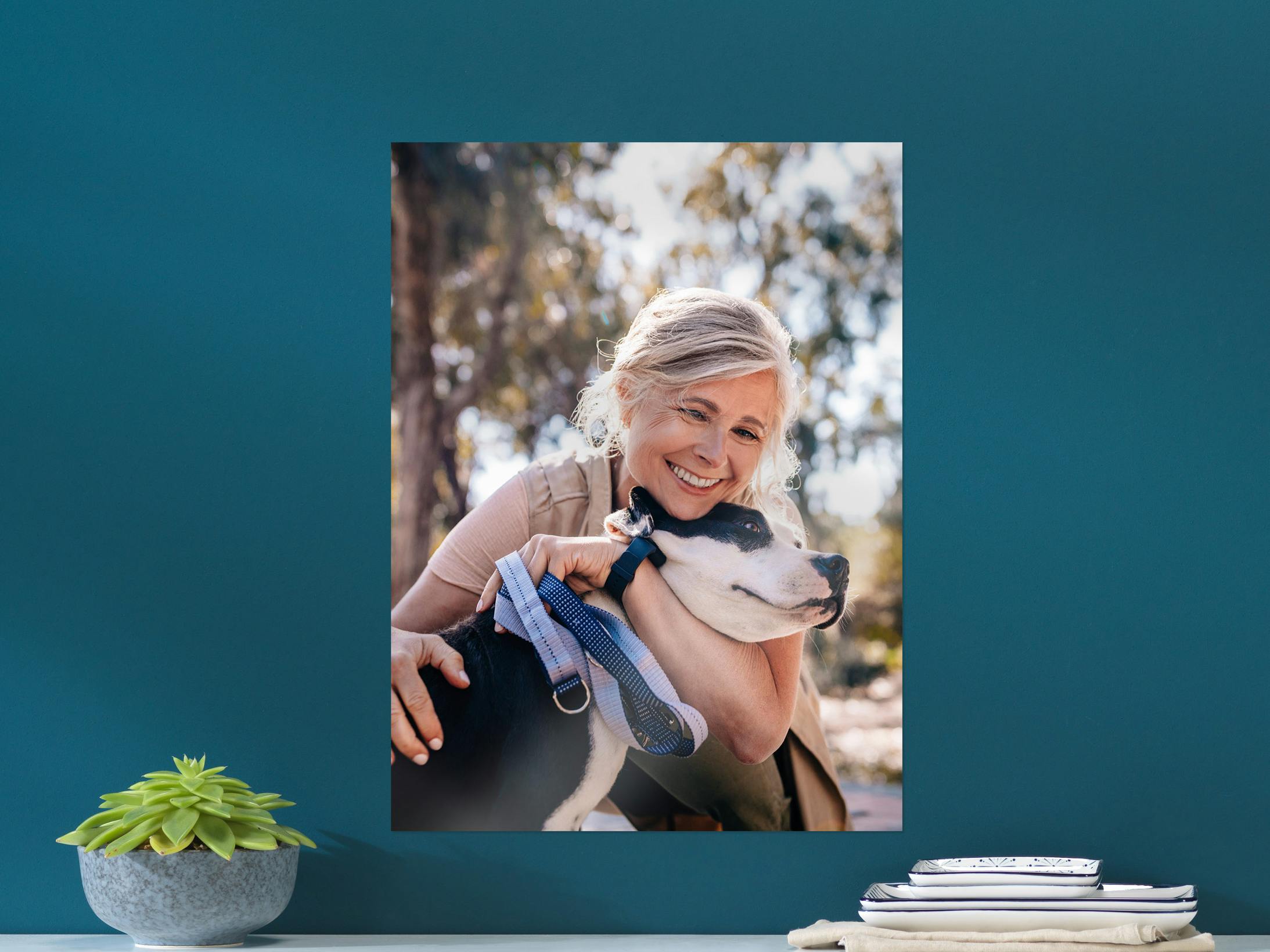 Poster photo accroché au mur avec photo d'une dame et de son chien sur un mur bleu foncé