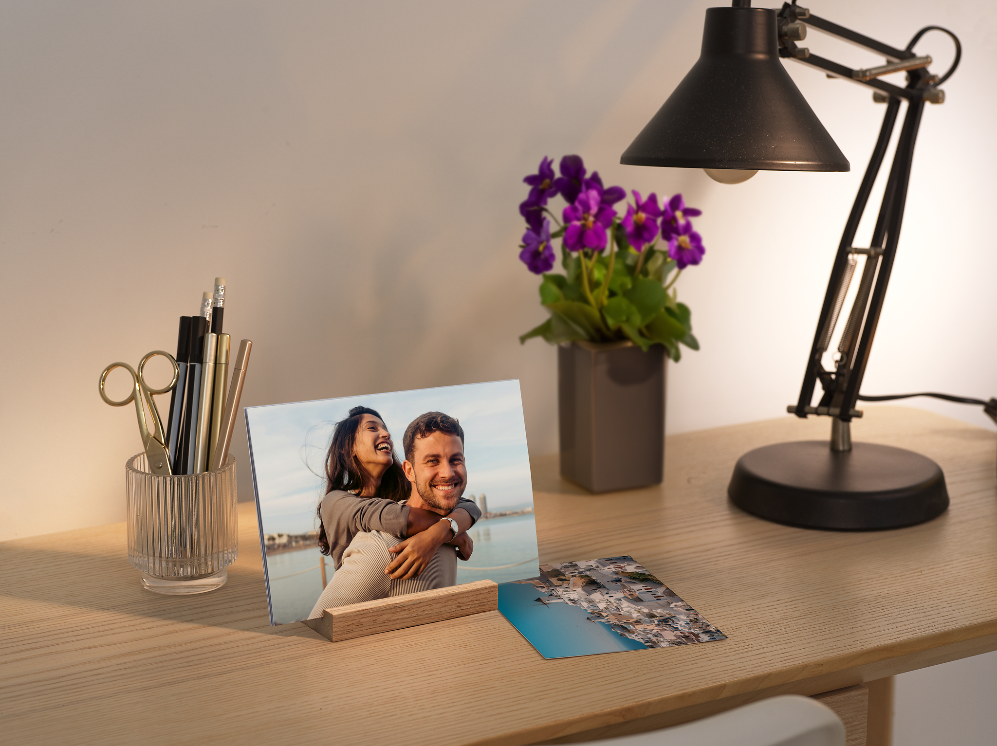 Stampe fotografiche con foto di coppia e supporto in legno sostenibile su una scrivania
