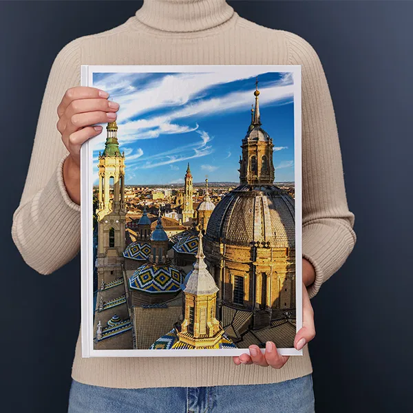 Una donna regge un Fotolibro Pixum XXL verticale