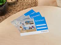 Pixum Geschenkgutschein Pixum Geschenkgutschein mit weihnachtlichen Motiven aufliegend auf einem Tisch