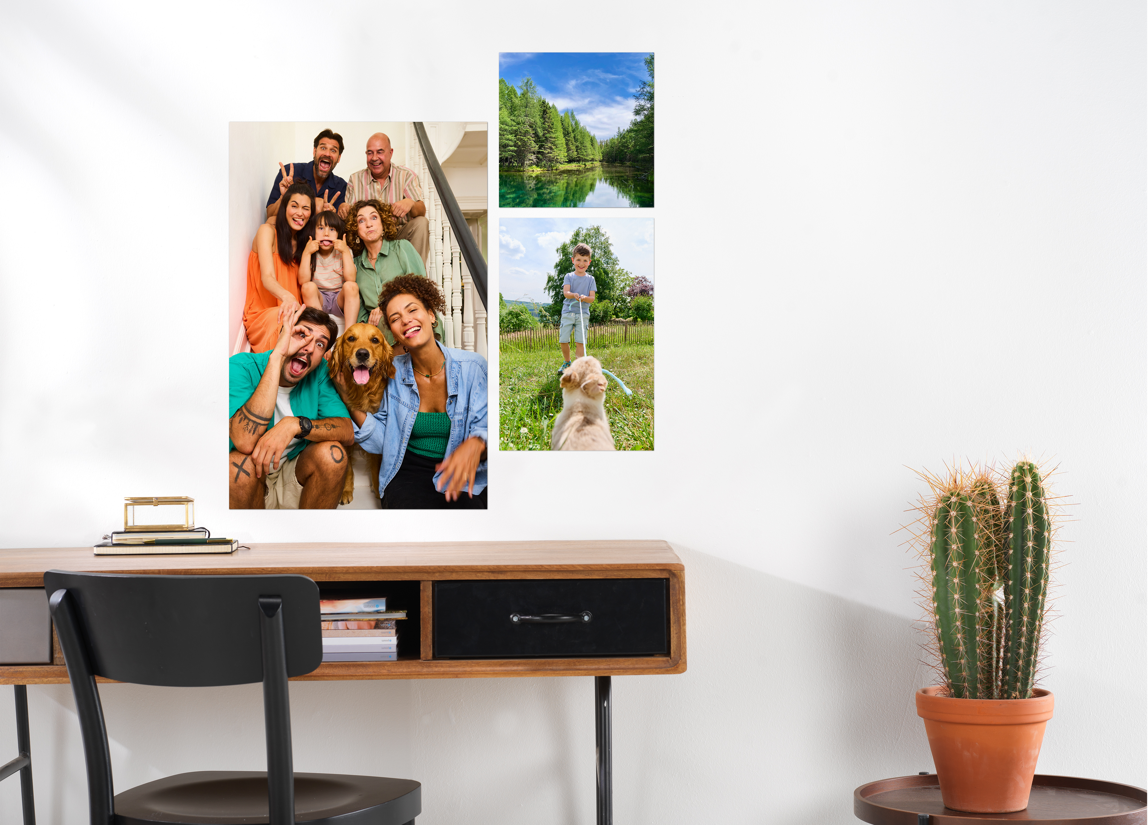 Meerdere fotoposters hangen boven een bureautafel aan de muur. Daarop staan familiefoto's een landschapfoto.