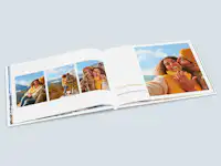 Geburtstagsfotobuch mit Meilensteinen Aufgeschlagenes Fotobuch als Geschenk zum Geburtstag mit Meilensteinen. Die aufgeschlagene Seite zeigen Verlobungsfotos vom Geburtstagskind.