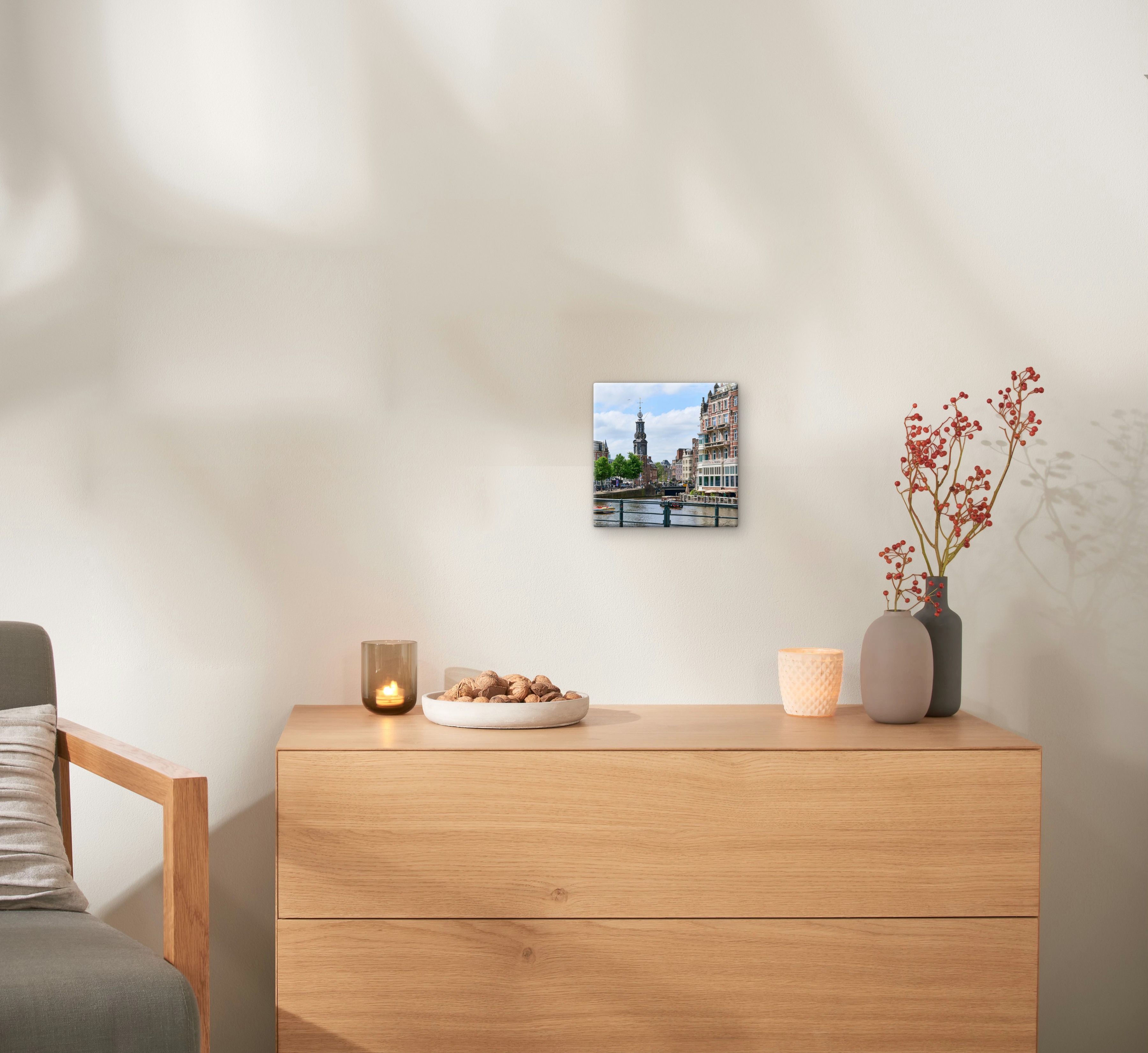 Een canvas in het formaat 20x20 cm met een foto van Amsterdam hangt aan de muur.