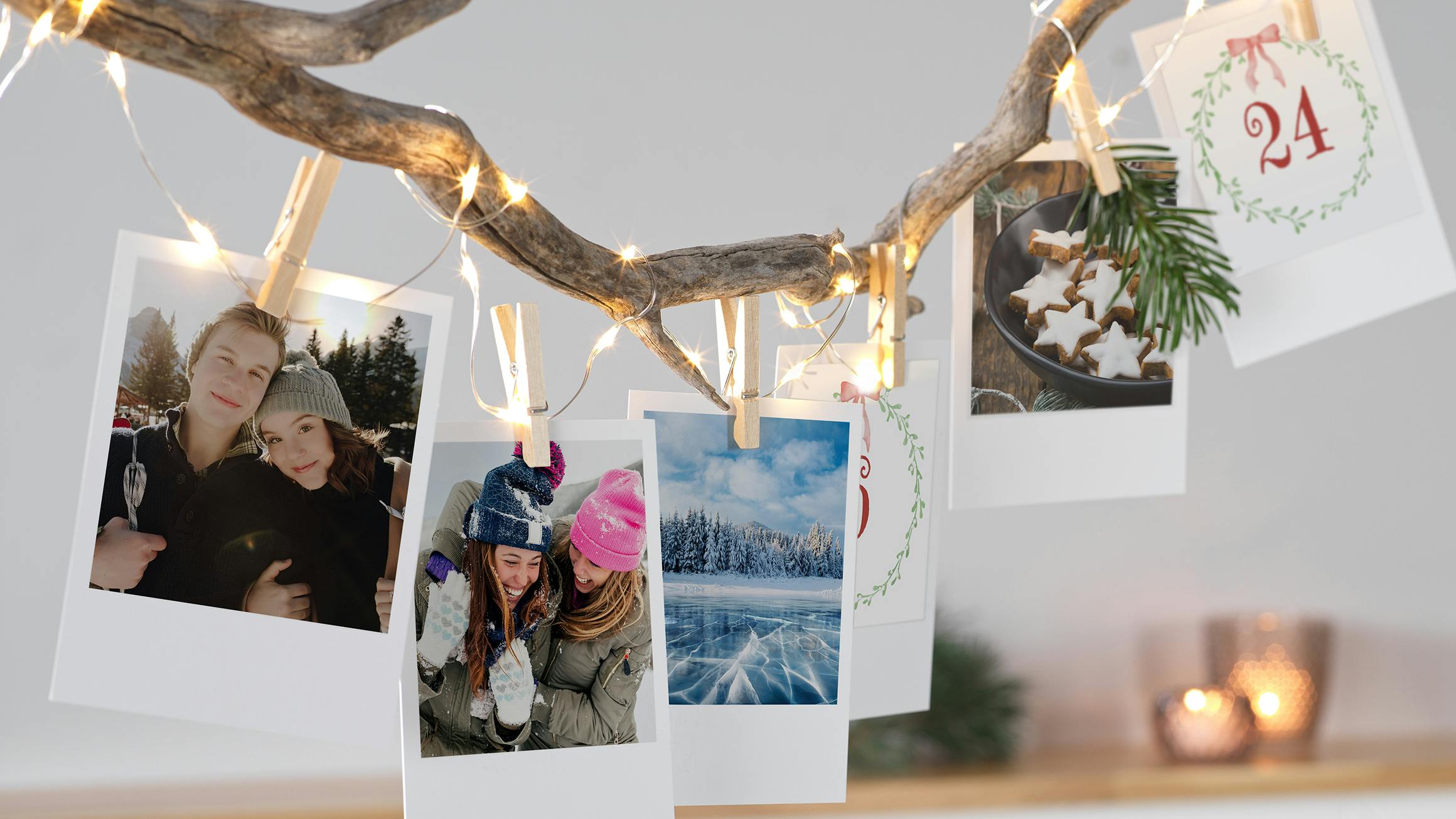 Retro-Adventskalender Adventskalender mit Retrofotos befestigt mit einer Lichterkette an einem Ast