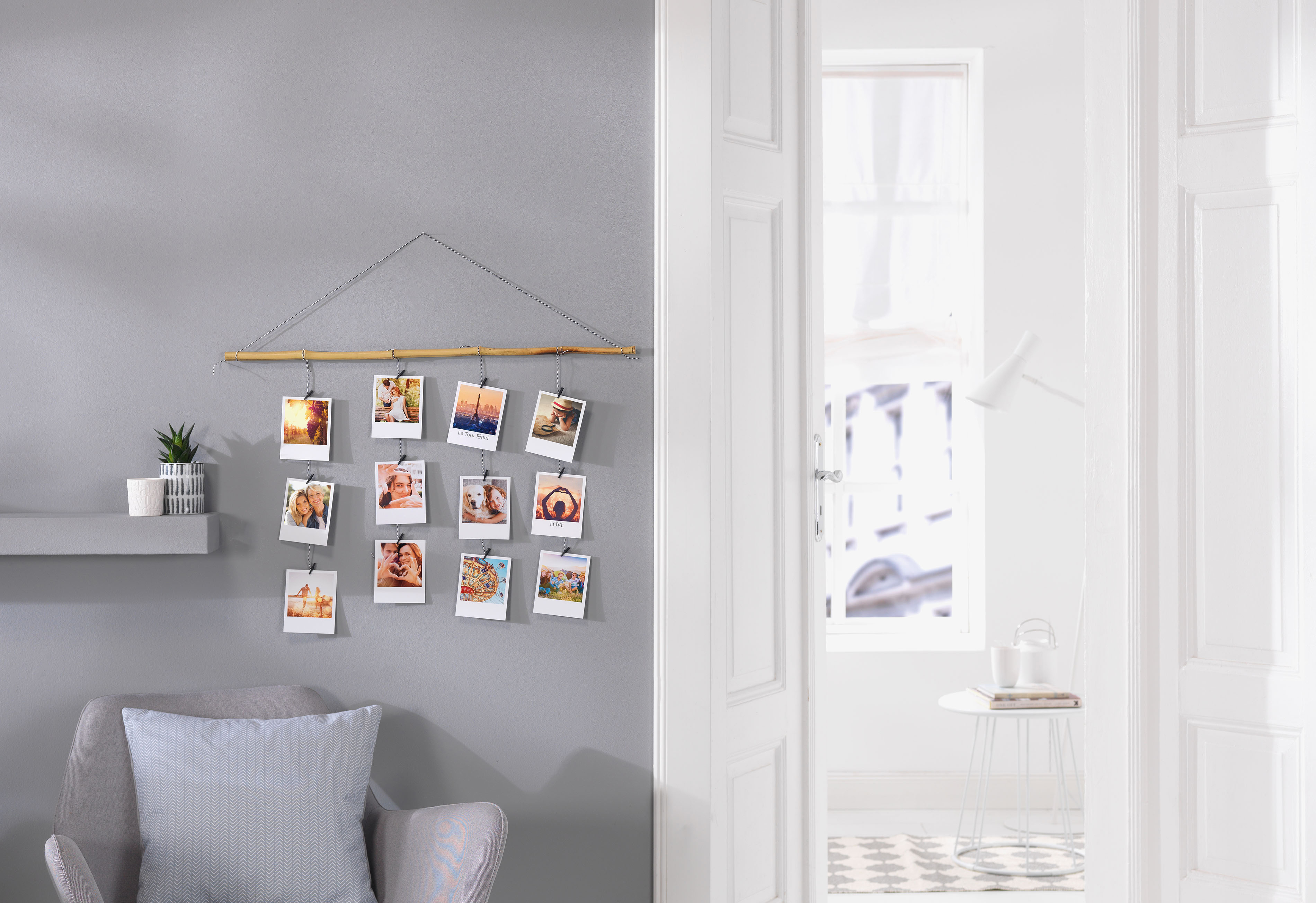 Fotomobile aus einem Ast mit Fäden mit Retro-Prints im Ambiente