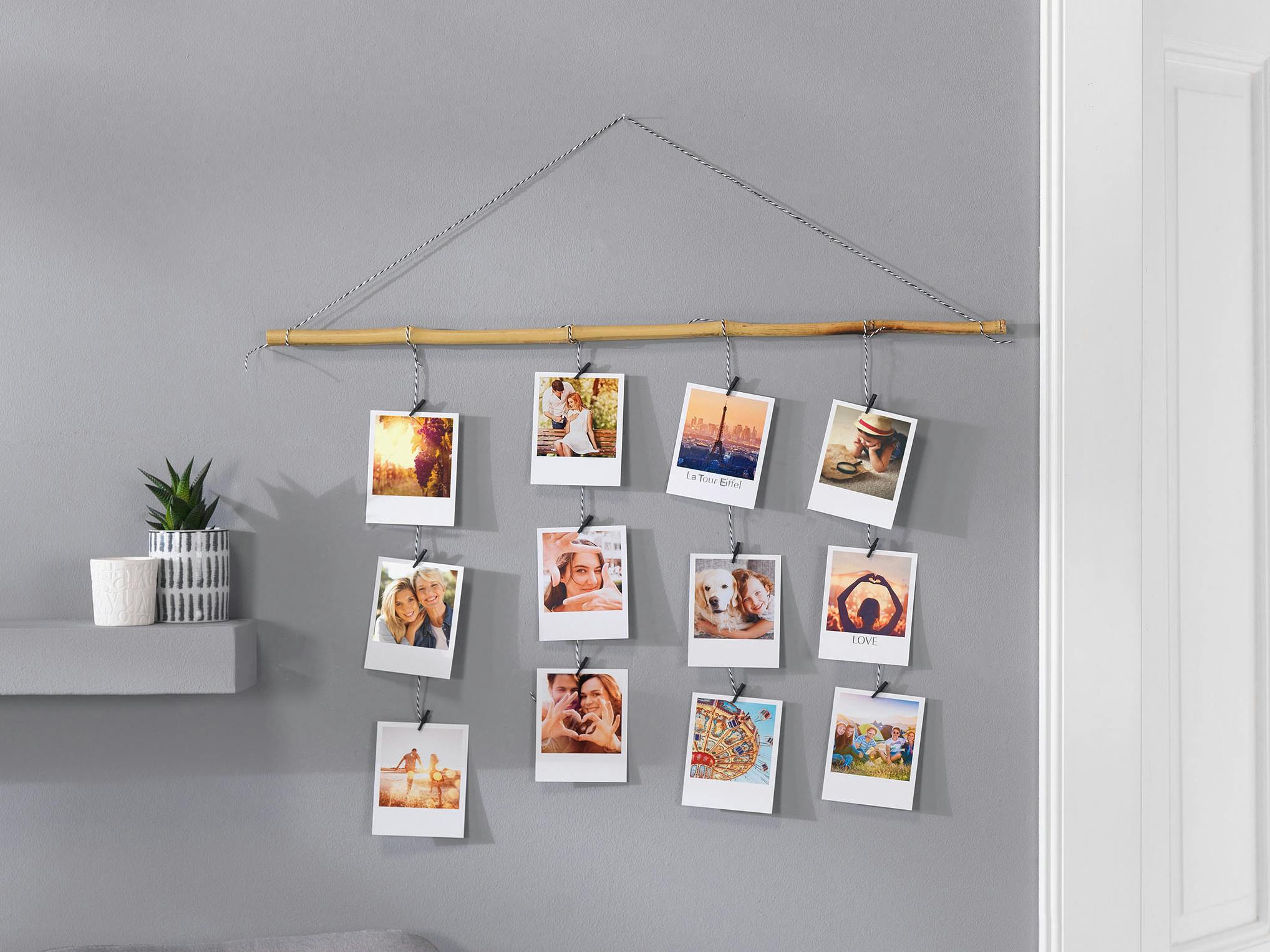 Porte-photo en bois avec tirages rétro Porte-photo en bois avec tirages rétro accrochés à la branche avec des cordes