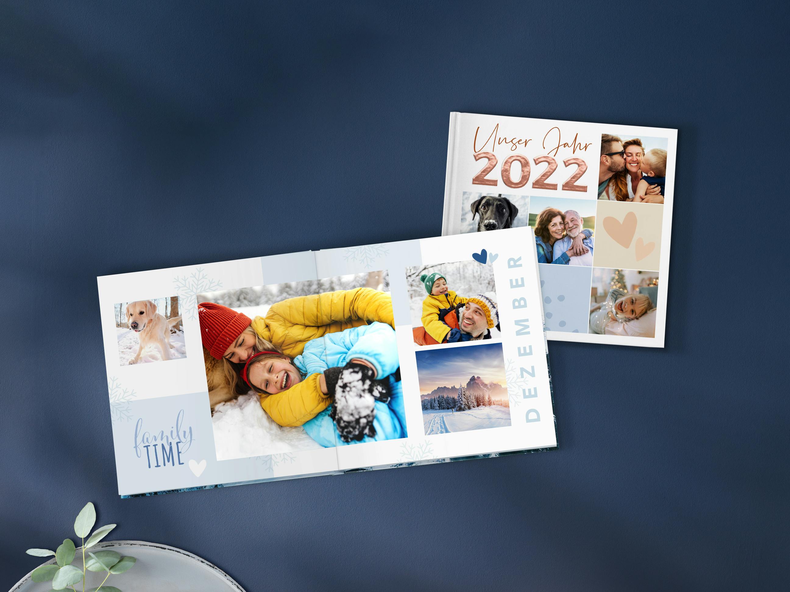 Geopend Pixum fotoboek in vierkant formaat met jaarboekdesign en winterse foto's van een gezin