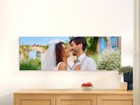 Pixum Fotoleinwand mit Hochzeitsmotiv in den Maßen 150 x 50 cm  Fotoleinwand  in den Maßen 150 x 50 cm an einer Wand mit Motiv eines Pärchens.