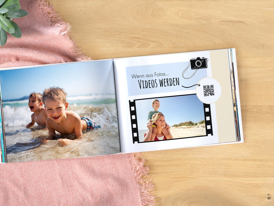 Pixum Fotobuch mit Urlaubsbildern einer Familie am Strand und einem eingefügten Video inkl. QR-Code