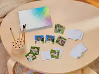 Foto-Memo-Spiel mit Kinderbildern Memo-Spiel mit Fotos von Kindern, einem Hund und einer Katze als Motiv auf einem Tisch.