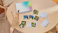 Foto-Memo-Spiel mit Kinderbildern Memo-Spiel mit Fotos von Kindern, einem Hund und einer Katze als Motiv auf einem Tisch.