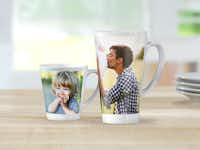 Koffiemok bedrukken Twee bedrukte koffiemokken met familiefoto's staan op een houten tafel.