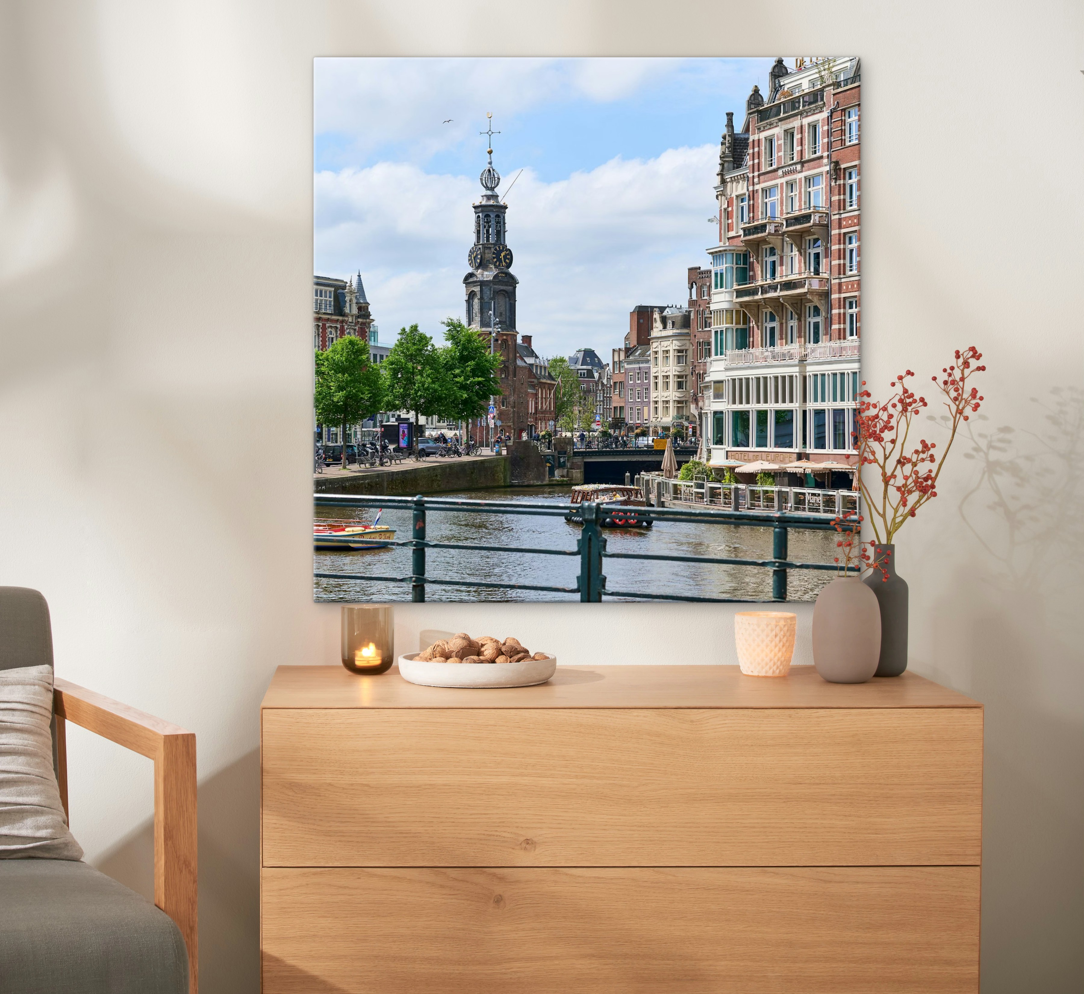 Een canvas in het formaat 80x80 cm met een foto van Amsterdam hangt aan de muur.