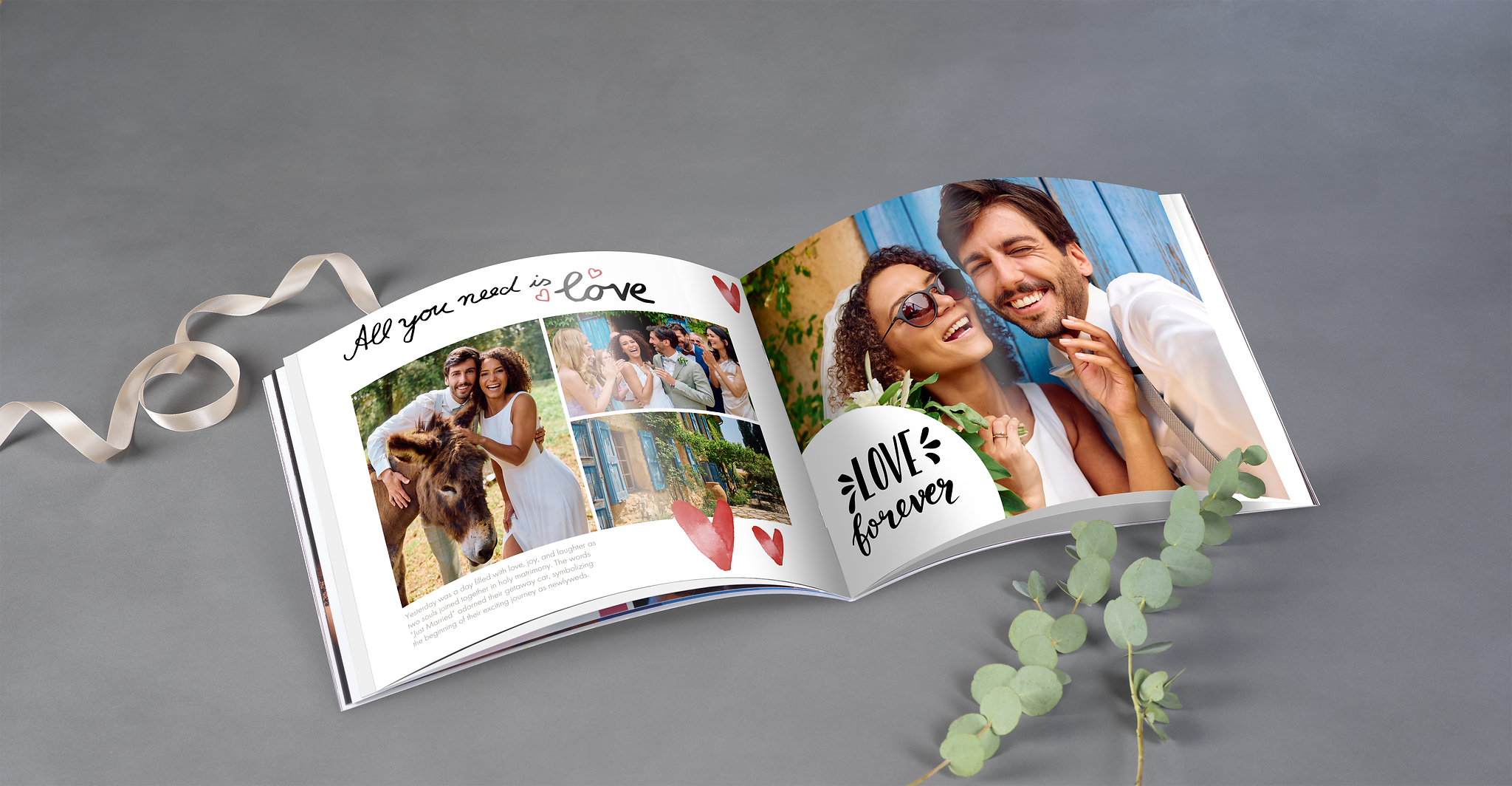 Offen liegendes Fotoheft mit Hochzeitsmotiven, dekoriert mit Eukalyptus und Band auf grauem Hintergrund